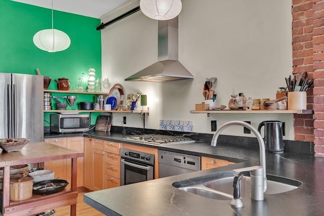 kitchen with open shelves, appliances with stainless steel finishes, wall chimney range hood, a sink, and dark countertops