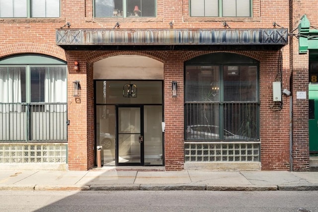 view of exterior entry featuring brick siding