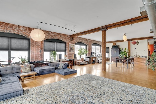 common area featuring brick wall and beamed ceiling
