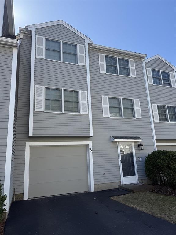 view of property featuring aphalt driveway and an attached garage