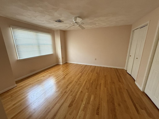 unfurnished bedroom featuring visible vents, baseboards, light wood-type flooring, and ceiling fan