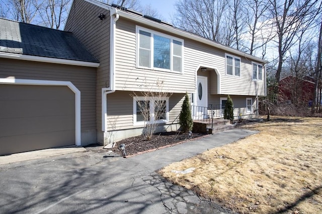 raised ranch with driveway and an attached garage