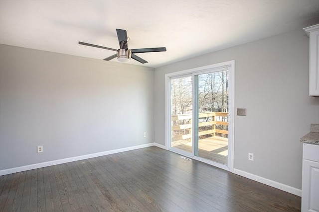 interior space featuring dark wood-type flooring, baseboards, and a ceiling fan