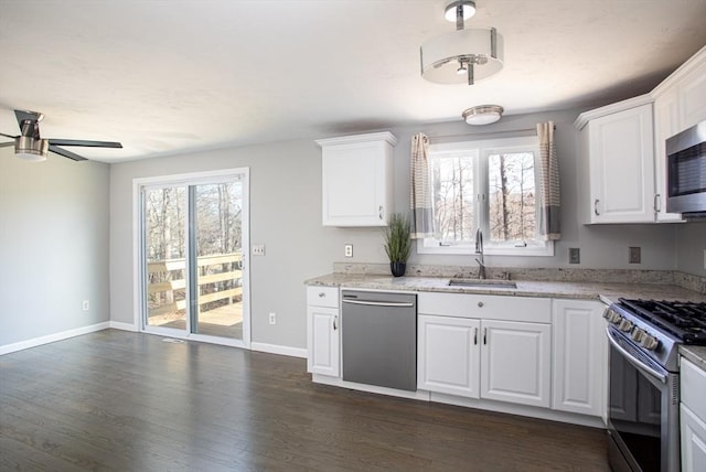 kitchen with stainless steel appliances, a sink, dark wood finished floors, and a healthy amount of sunlight