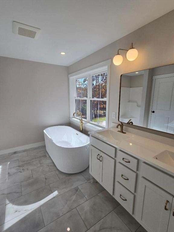 bathroom featuring vanity and a tub