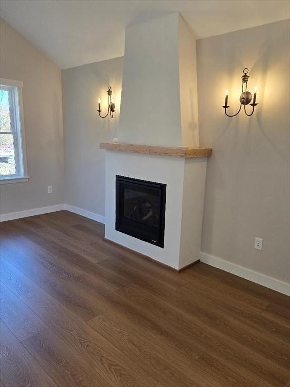 unfurnished living room with vaulted ceiling and dark hardwood / wood-style floors