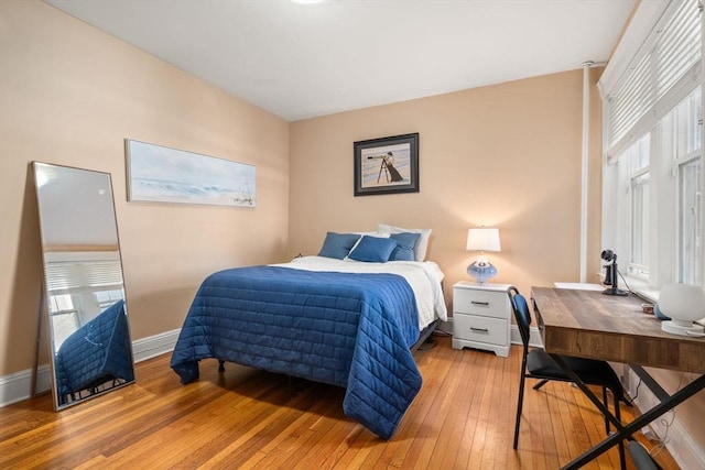 bedroom with hardwood / wood-style flooring and baseboards