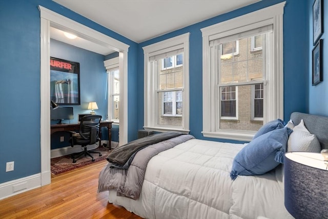 bedroom featuring baseboards and light wood finished floors