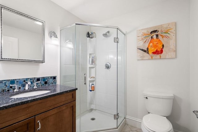 bathroom with vanity, a shower stall, toilet, and decorative backsplash