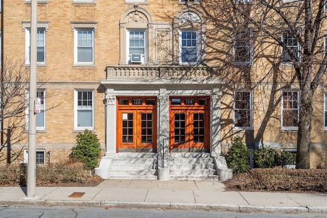 view of front of house featuring brick siding, cooling unit, and french doors