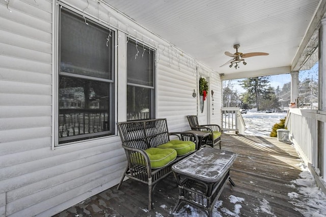 snow covered deck with ceiling fan and covered porch