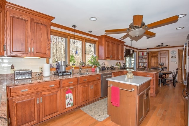 kitchen with pendant lighting, stainless steel dishwasher, light wood-type flooring, and sink