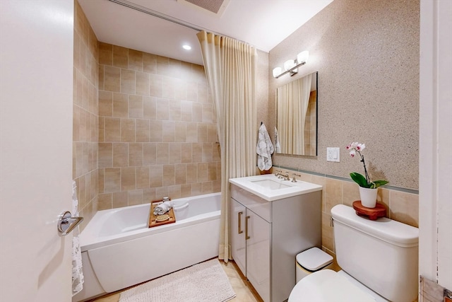 full bathroom featuring shower / bathtub combination, toilet, vanity, and tile walls