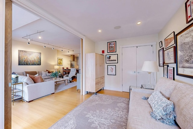 bedroom featuring a closet, light hardwood / wood-style flooring, and track lighting