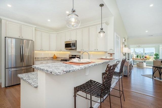 kitchen featuring white cabinets, kitchen peninsula, stainless steel appliances, and hanging light fixtures