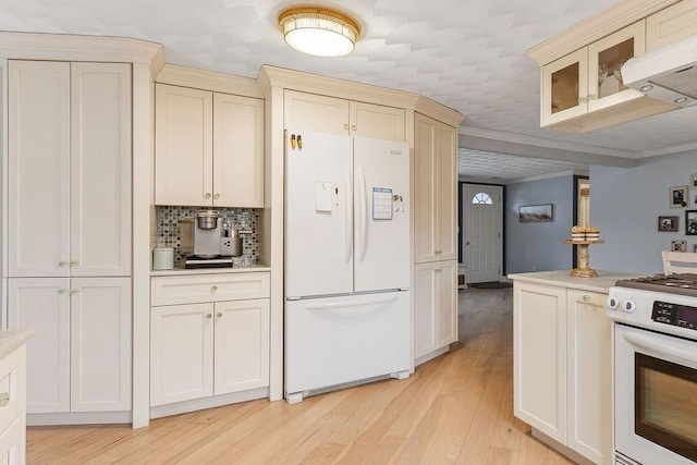 kitchen featuring light wood-style flooring, white appliances, light countertops, ornamental molding, and cream cabinetry