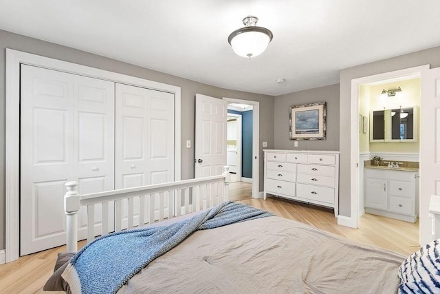 bedroom featuring baseboards, a closet, connected bathroom, and light wood-style floors