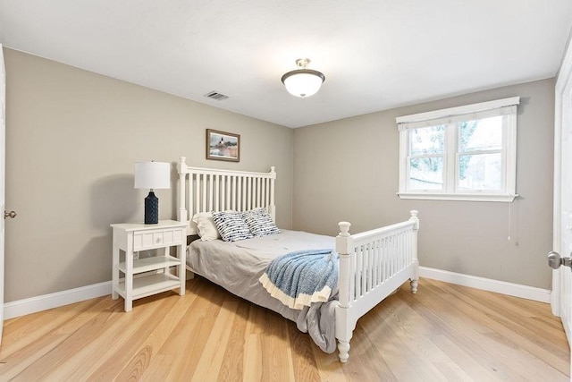 bedroom featuring light wood-style floors, baseboards, and visible vents