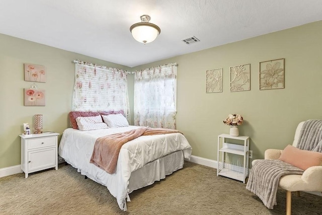 bedroom featuring visible vents, light carpet, and baseboards