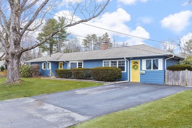 single story home featuring a chimney, a shingled roof, fence, driveway, and a front lawn