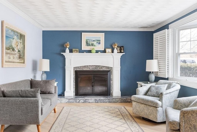 living area featuring crown molding, a premium fireplace, and light wood-style floors