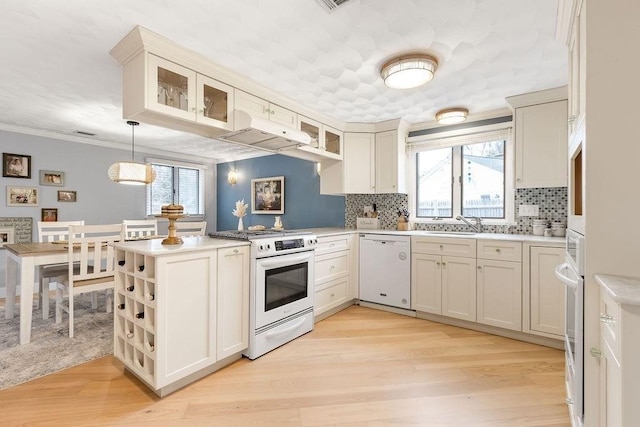 kitchen with white appliances, plenty of natural light, and decorative backsplash