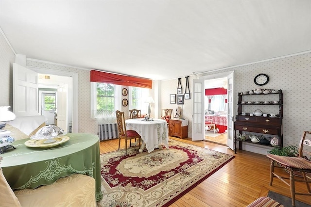96 College St, South Hadley, MA 01075 - dining area featuring wallpapered walls, radiator, ornamental molding, and light wood-style flooring