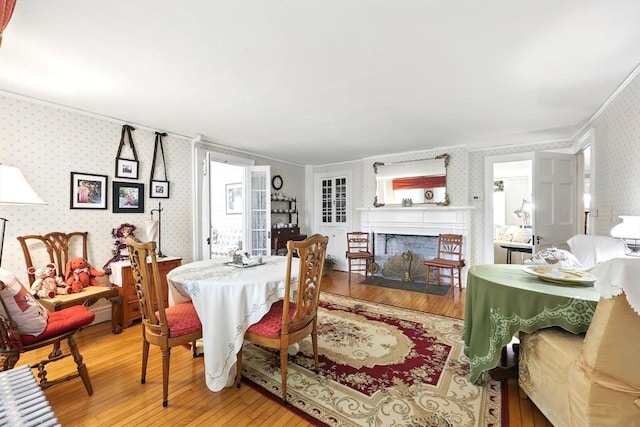 96 College St, South Hadley, MA 01075 - dining area featuring wallpapered walls, light wood-style flooring, crown molding, and a fireplace