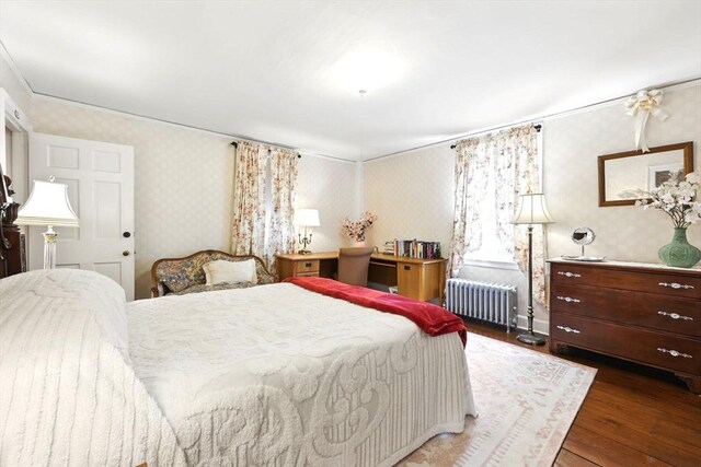 96 College St, South Hadley, MA 01075 - bedroom featuring radiator heating unit, wallpapered walls, wood finished floors, and ornamental molding