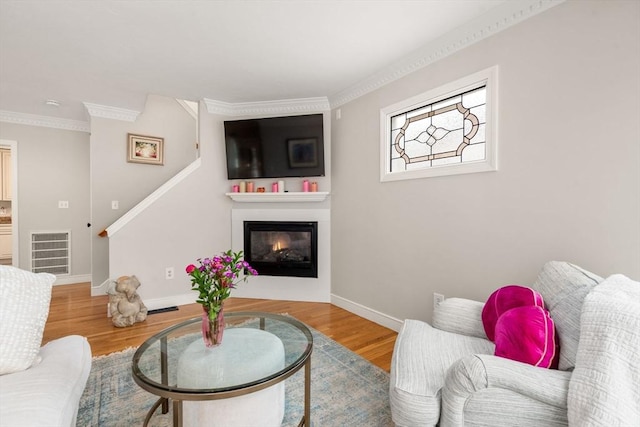 137 Pond, Westwood, MA 02090 - living area with a glass covered fireplace, ornamental molding, baseboards, wood finished floors, and stairway