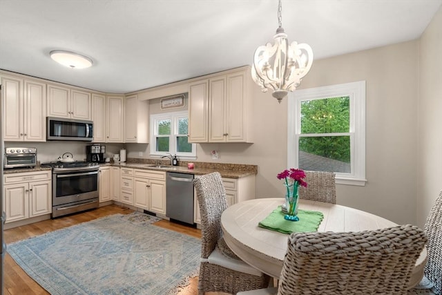137 Pond, Westwood, MA 02090 - kitchen featuring stainless steel appliances, cream cabinets, a chandelier, and a sink