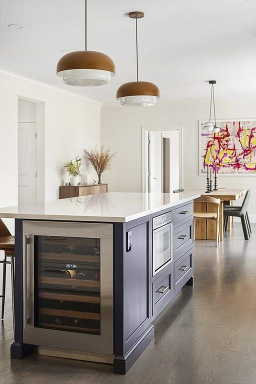 5 Bullens Way, Canton, MA 02021 - kitchen featuring beverage cooler, crown molding, dark wood-style flooring, light countertops, and a kitchen island