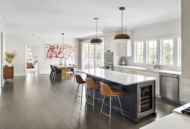 5 Bullens Way, Canton, MA 02021 - kitchen with appliances with stainless steel finishes, a sink, beverage cooler, healthy amount of natural light, and ornamental molding