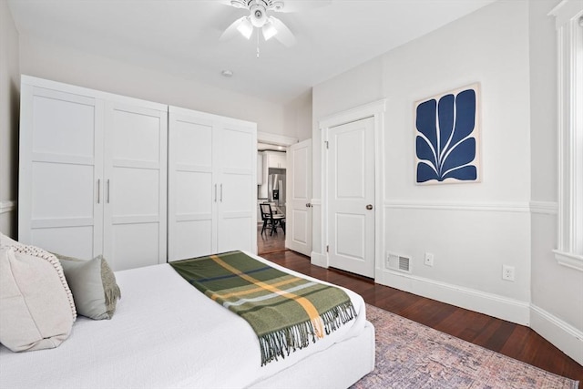 bedroom with visible vents, a ceiling fan, dark wood-type flooring, and baseboards