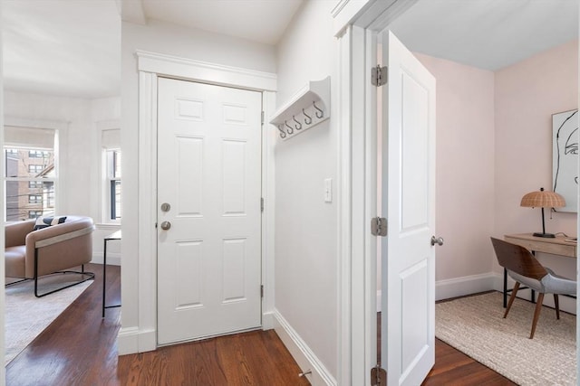 foyer with baseboards and dark wood-style flooring