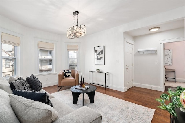 living room with a notable chandelier, wood finished floors, and baseboards