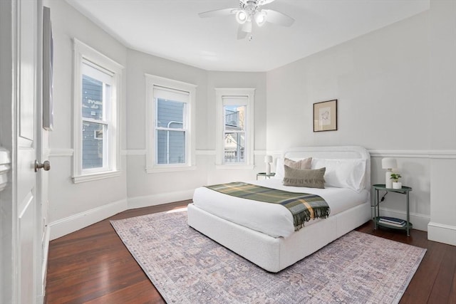 bedroom with baseboards, multiple windows, dark wood-style floors, and a ceiling fan