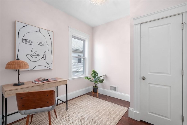 office space with dark wood finished floors, visible vents, a baseboard heating unit, and baseboards