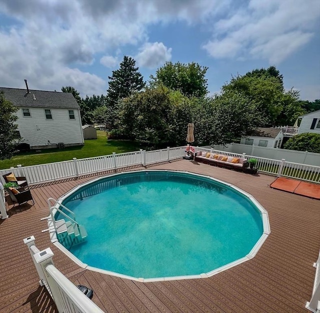 view of pool with fence, a fenced in pool, and a wooden deck