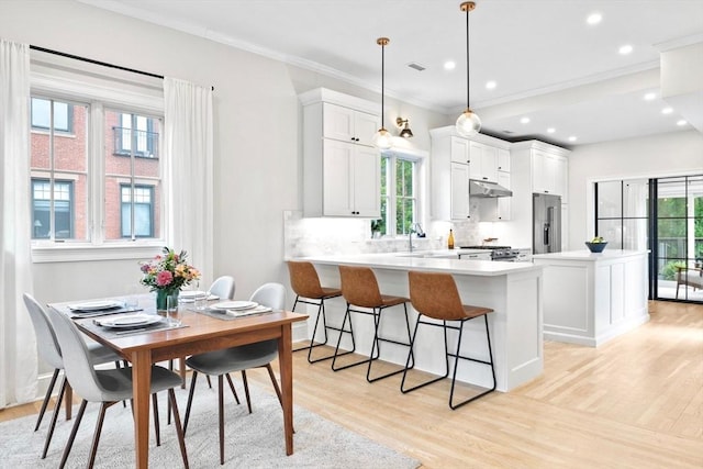 356 Bunker Hill St Unit 2, Boston, MA 02129 - kitchen with appliances with stainless steel finishes, under cabinet range hood, light wood-type flooring, backsplash, and ornamental molding