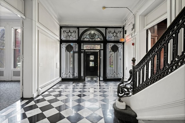 foyer entrance with a wealth of natural light, a baseboard radiator, dark colored carpet, and crown molding