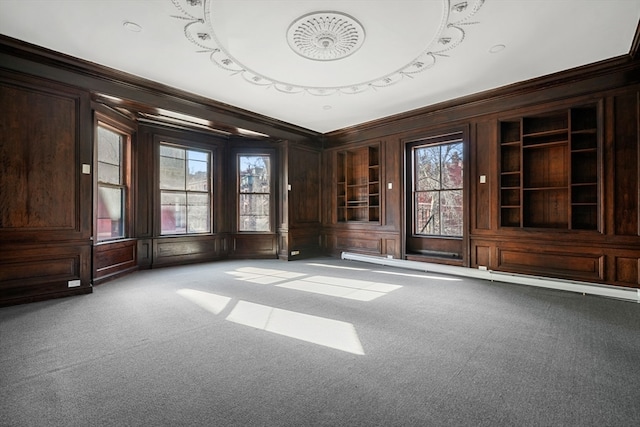 carpeted spare room featuring a wealth of natural light and ornamental molding