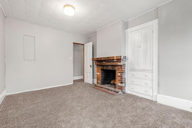unfurnished living room with carpet flooring, a fireplace, baseboards, and ornamental molding