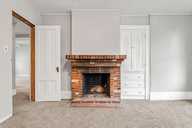 unfurnished living room featuring carpet, a fireplace, ornamental molding, and baseboards