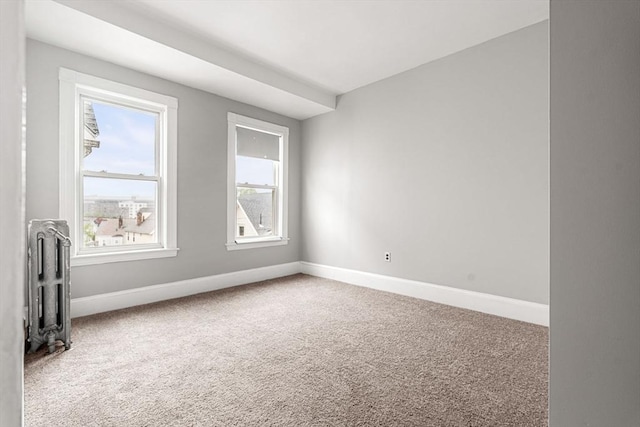 unfurnished room featuring radiator heating unit, carpet flooring, and baseboards