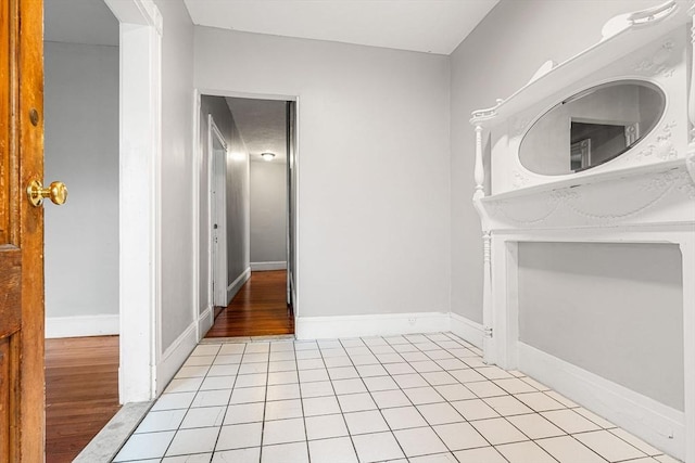 corridor featuring light tile patterned floors and baseboards