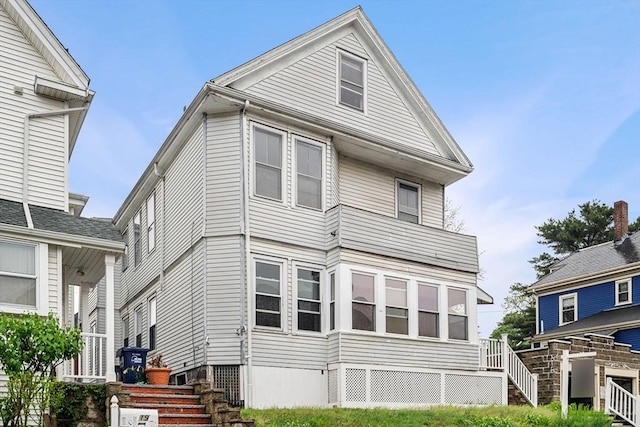 rear view of property featuring stairs