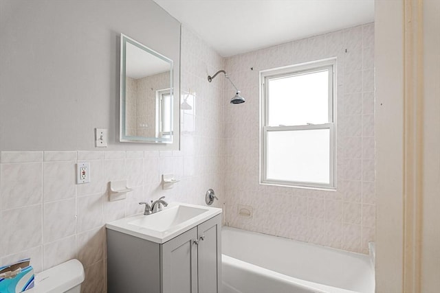 full bathroom featuring tile walls, shower / bath combination, toilet, and vanity