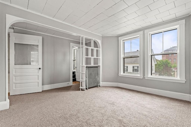 unfurnished bedroom featuring carpet flooring, crown molding, and baseboards