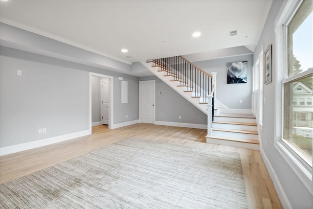 unfurnished living room featuring ornamental molding and light hardwood / wood-style floors